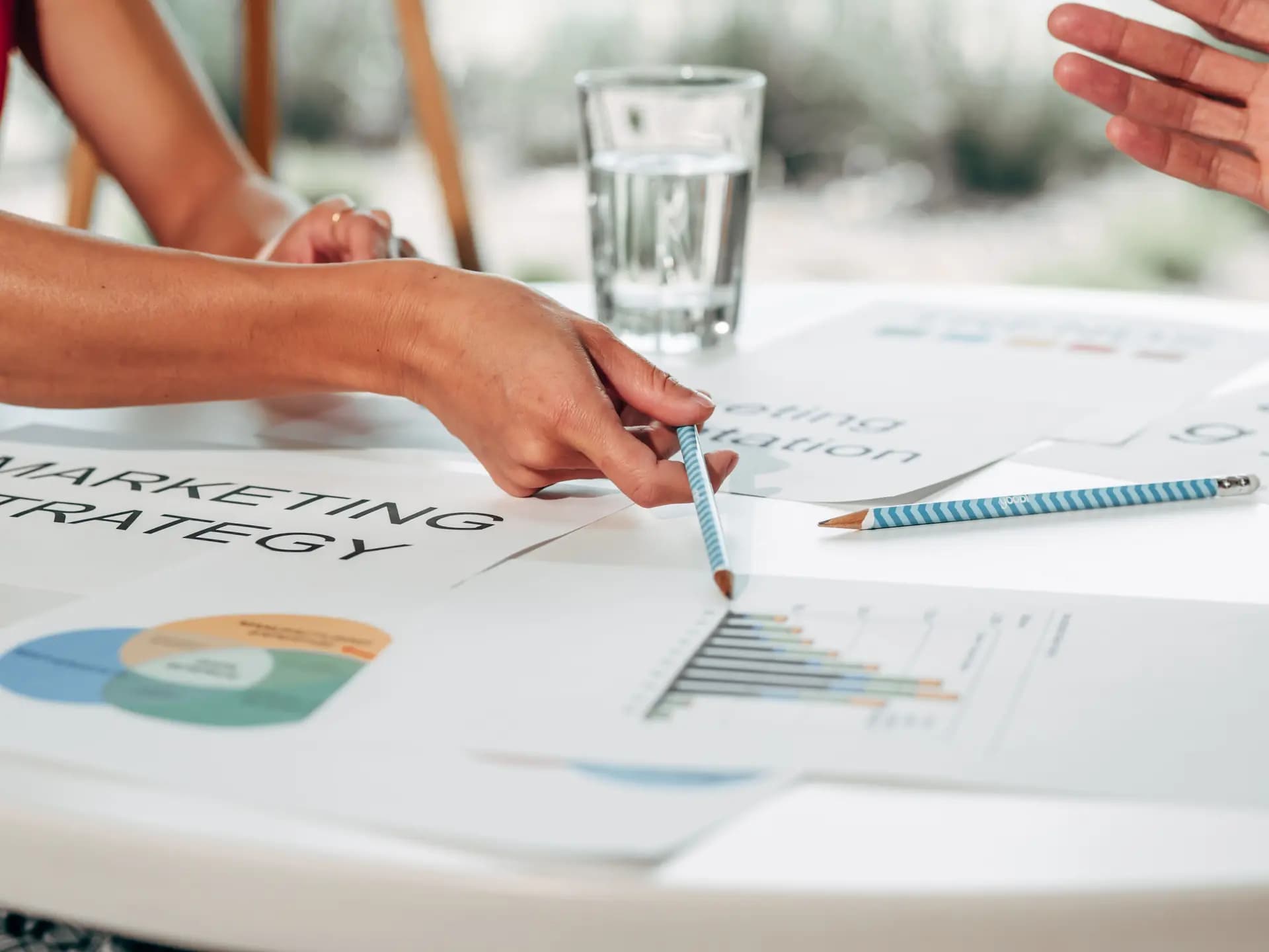 Estrategia de marketing con gráficos y manos señalando
